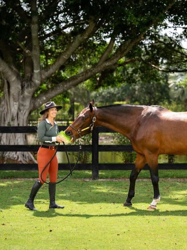 Ashlee Bond hand-feeding Equi Greens to her horse