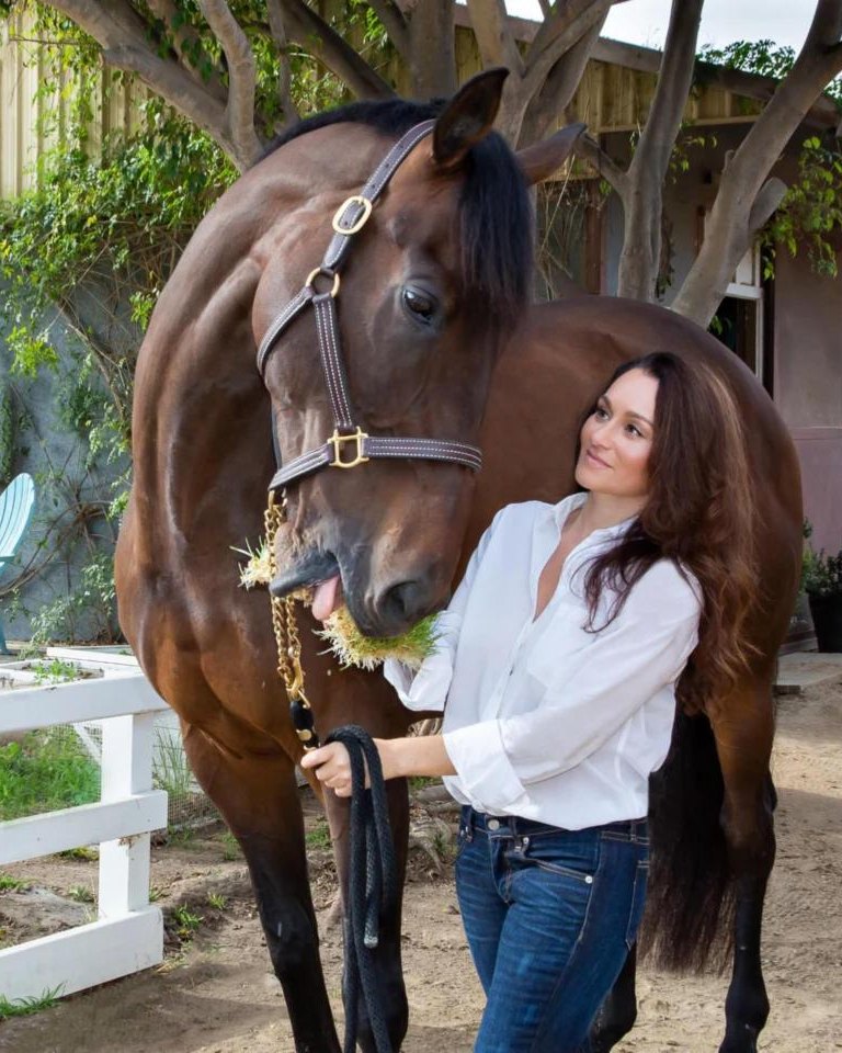 Equi Greens founder Jennifer Apelian feeding sprouted barley grass to her horse